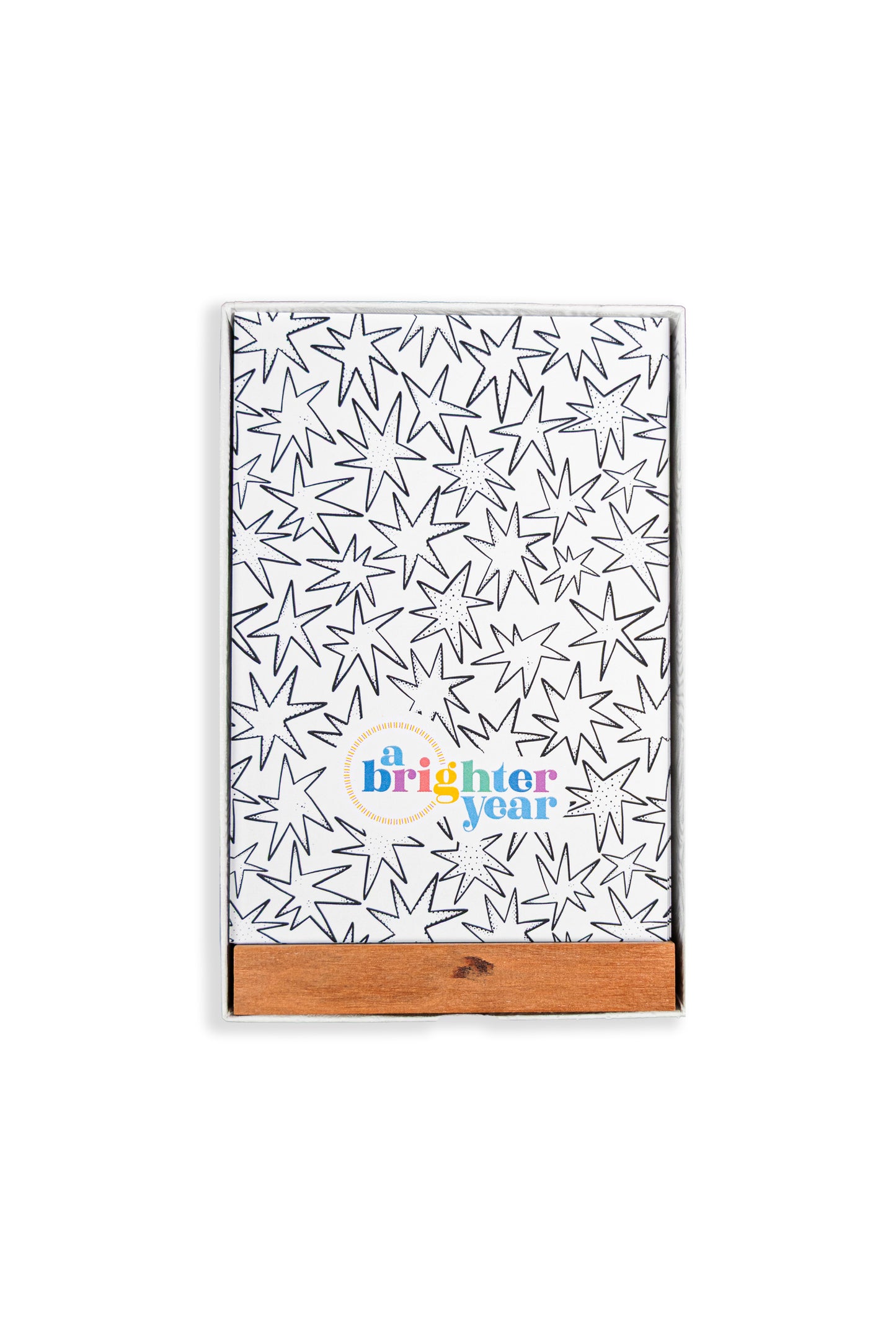 A color your own tarot deck in a box with a black starburst pattern and a colorful 'a Brighter year' logo near the bottom. It has a natural wood slide cover and is photographed on a clean white background.