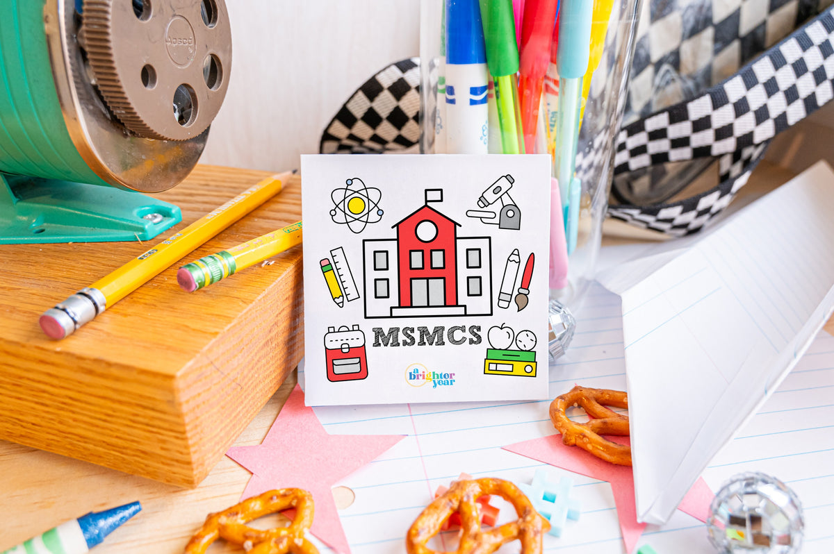 Mount St. Michael Catholic School mini coloring book with an MSMCS school-house cover, surrounded by pencils and school supplies